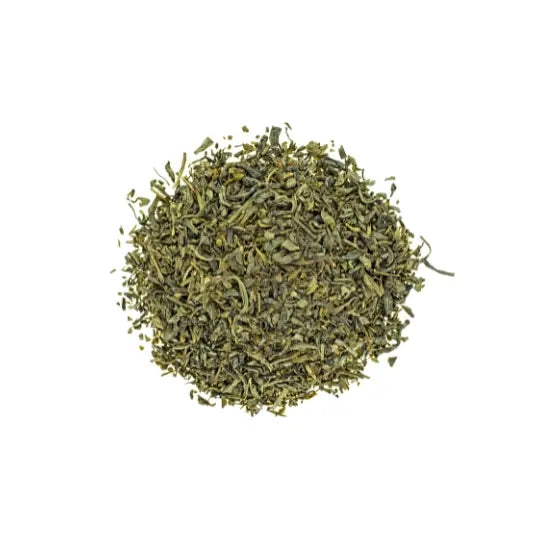 Finely ground dried tea leaves, rich in natural caffeine, displayed on a white background.